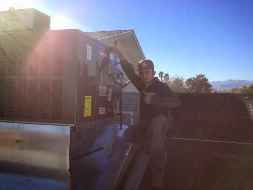 HVAC technician performing Heat Pump Repair on a rooftop unit in Doylestown